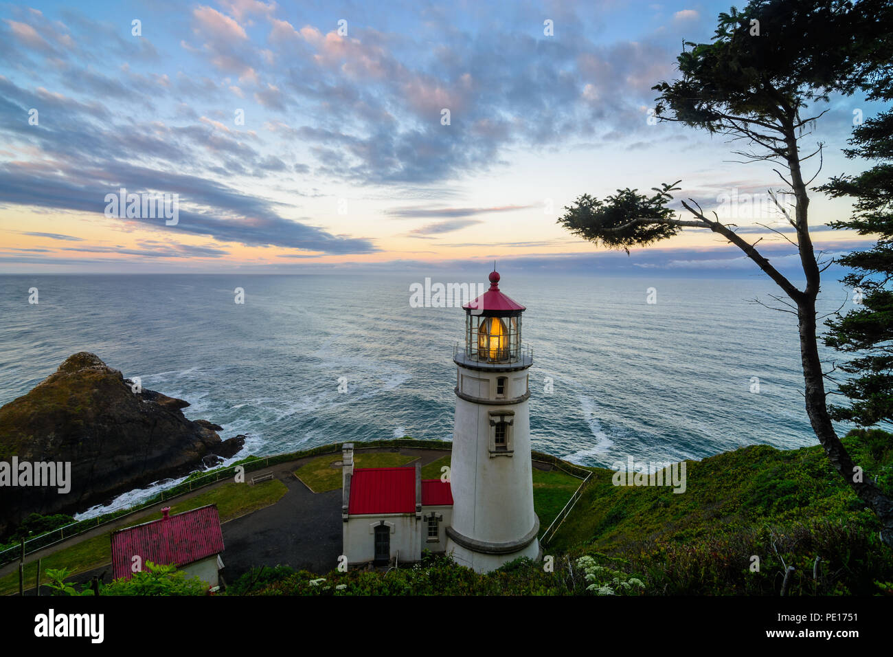 Bands of clouds float over Heceta Head Lighthouse along the shore of the Pacific Ocean along the Central Oregon Coast in June 2018. Stock Photo