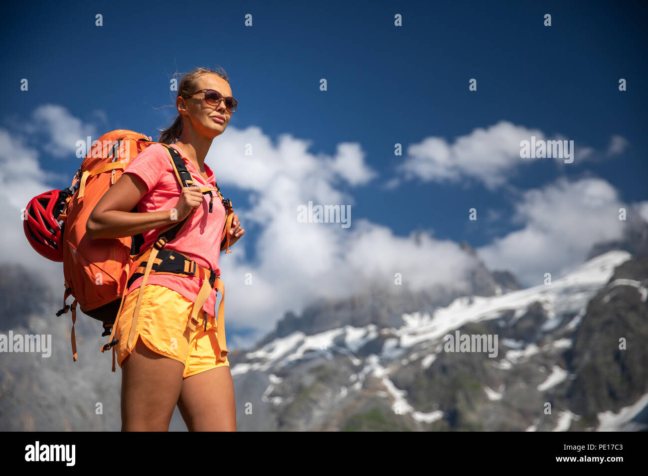 Pretty, female hiker/climber in a lovely alpine setting of Swiss Alps ...