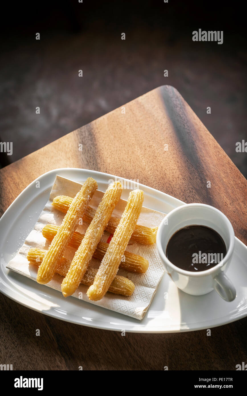 churros con chocolate traditional spanish sweet breakfast set on wooden table Stock Photo