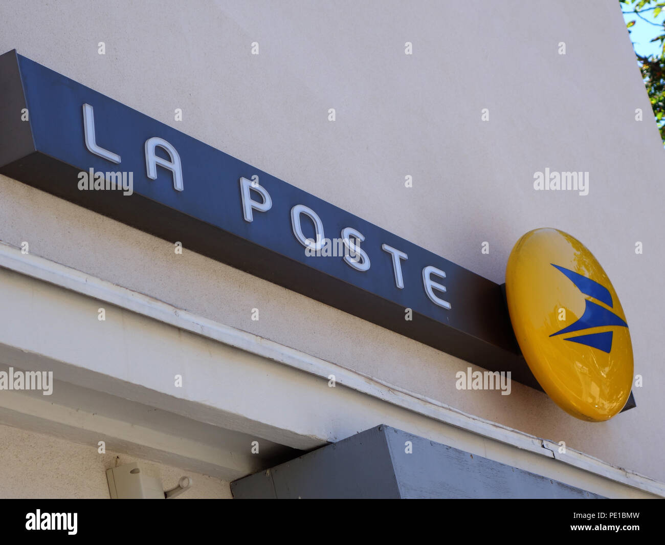 Signs with name and post office logo on the wall of the postal service