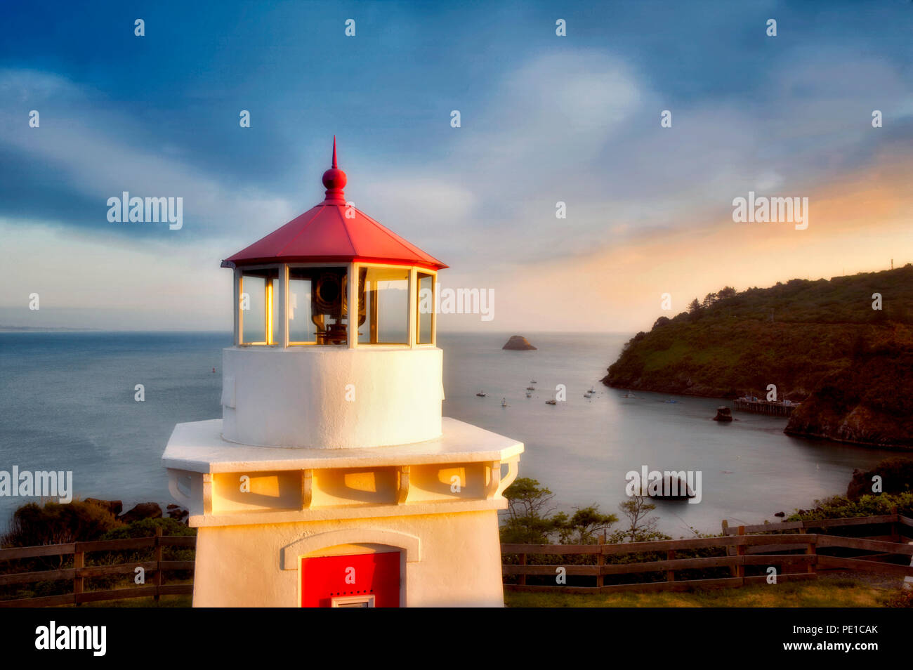 Trinidad Lighthouse with boats in harbor and sunset. California Stock Photo