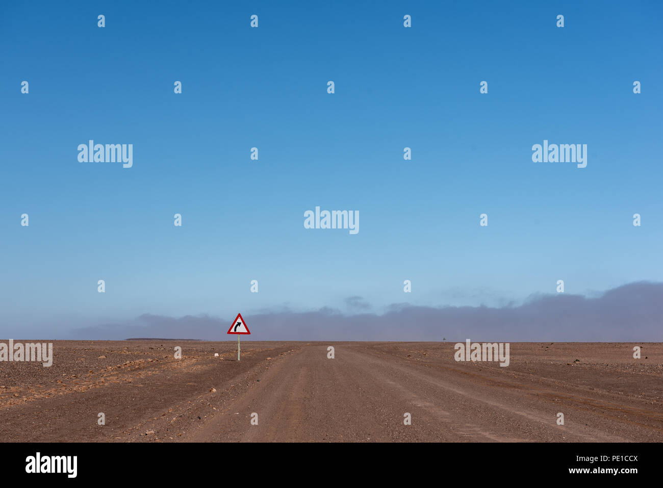 Bend street sign for curve with gravel road and blue sky Stock Photo