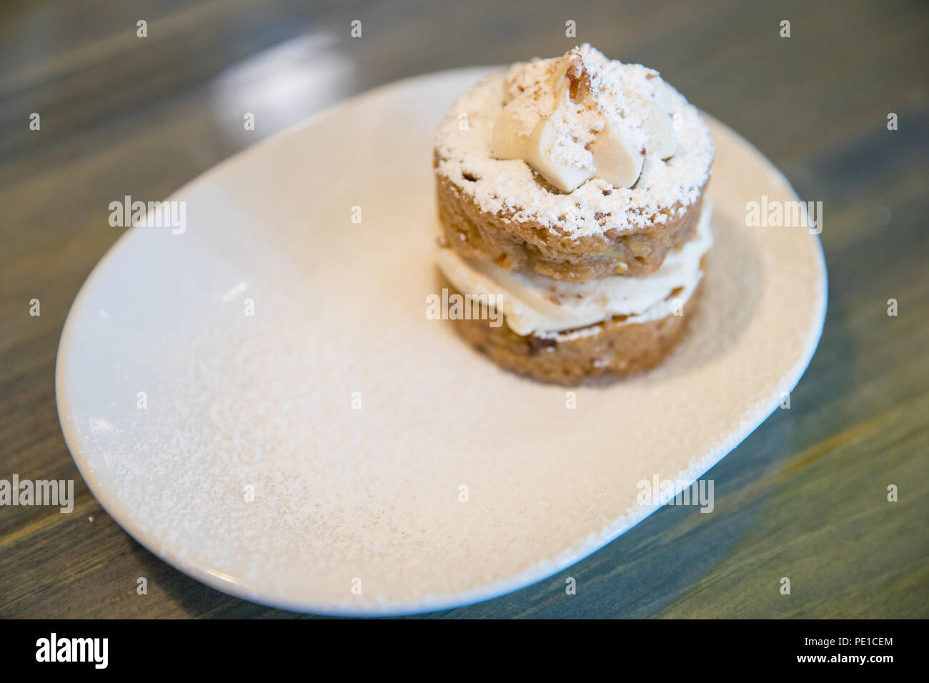 Homemade fruity Hummingbird cake with walnuts and cinnamon on the white plate. Stock Photo