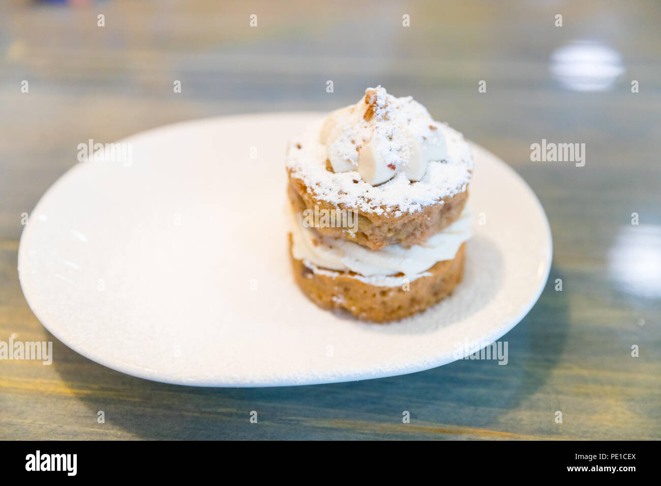 Homemade fruity Hummingbird cake with walnuts and cinnamon on the white plate. Stock Photo