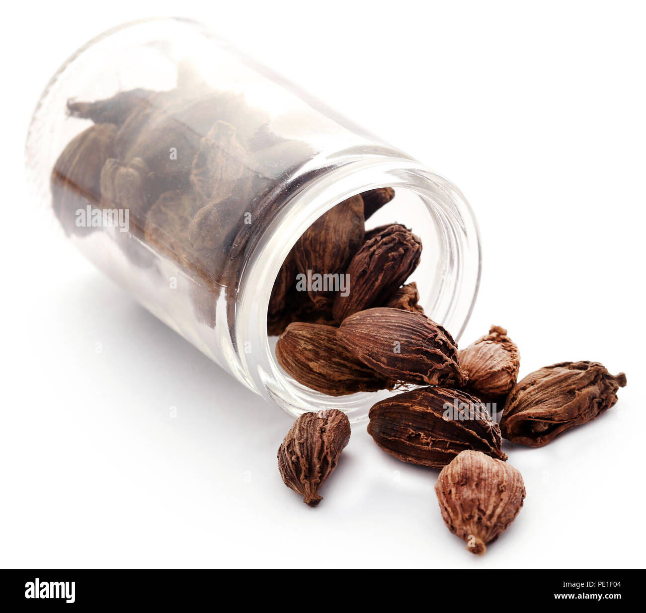 Black cardamom in a glass jar over white background Stock Photo