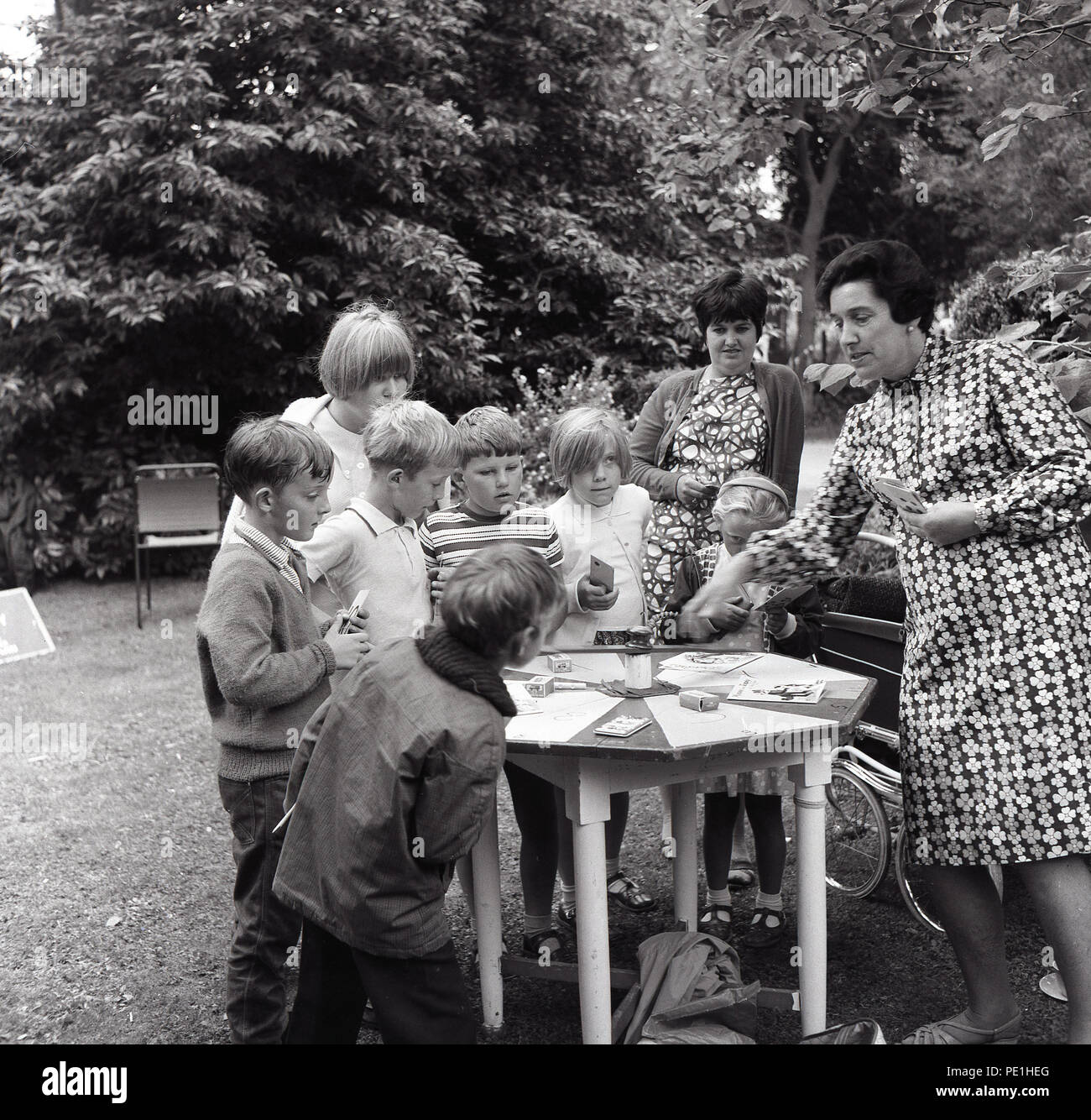 1960s Outdoors At A Village Fete A Group Of Young Children Gather Around A Table Playing A Card Game Hosted By A Lady England Uk Stock Photo Alamy 1960s Outdoors At A Village Fete A Group Of Young Children Gather Around A Table Playing A Card Game Hosted By A Lady England Uk Stock Photo Alamy