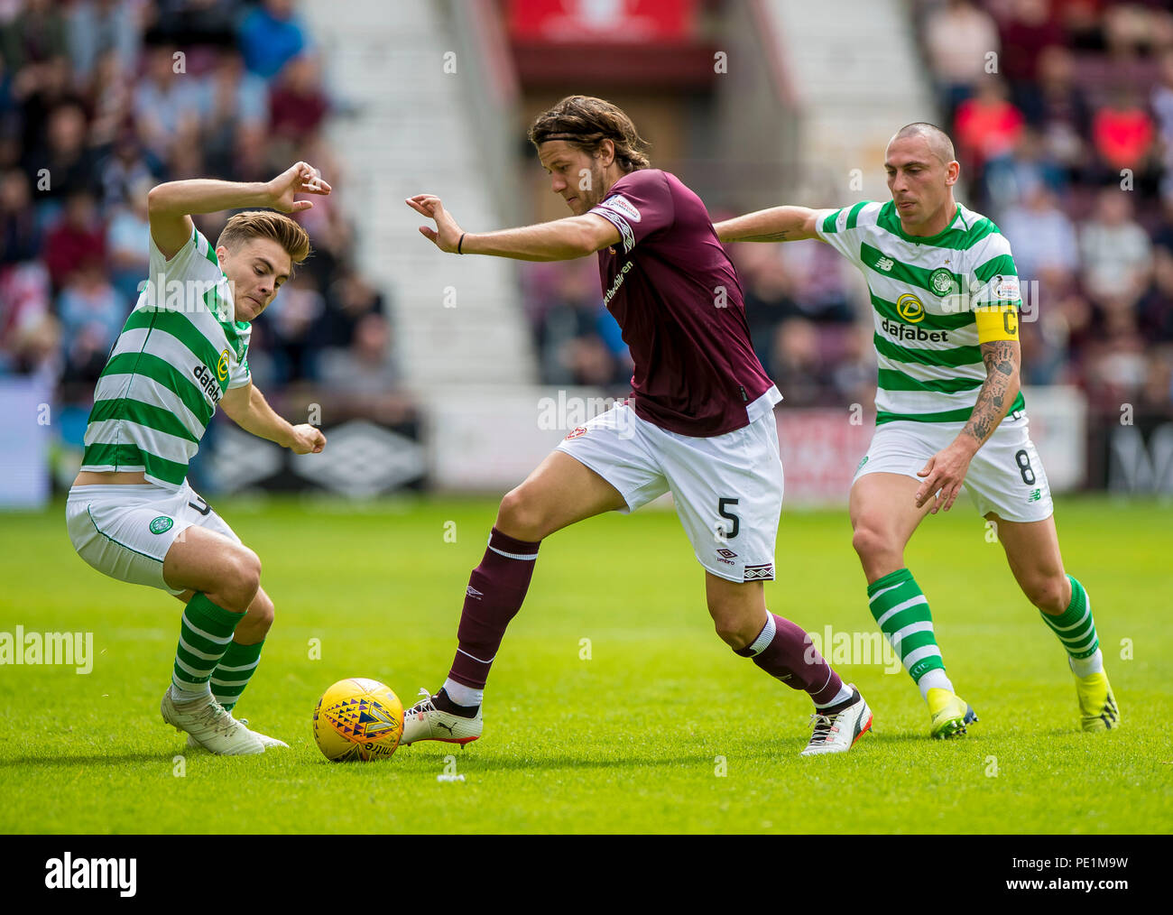 Celtic's James Forrest Hearts' Peter Haring and Celtic's Scott Brown compete for the ball during the Ladbrokes Scottish Premiership match at Tynecastle Stadium, Edinburgh. Stock Photo