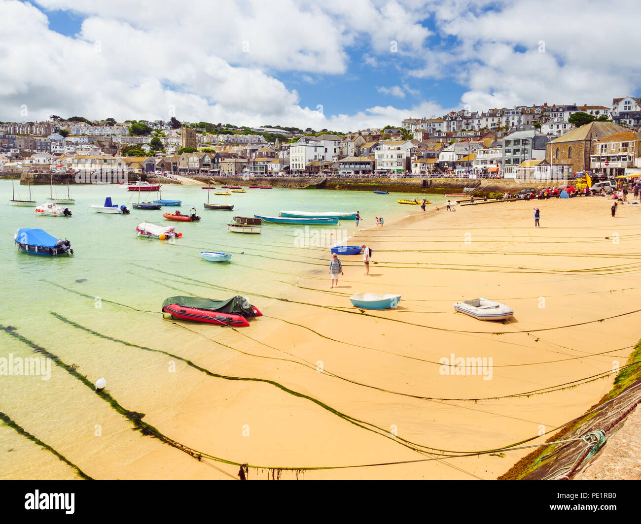 ST IVES, ENGLAND - JUNE 19: A couple walking along the golden sands of St Ives beach in Cornwall, on a hot, Summer day. In St Ives, England. On 19th J Stock Photo