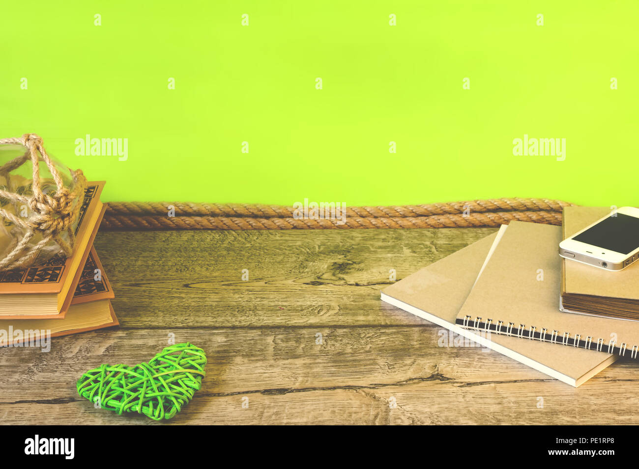 School notebooks, pencils and other items on green and wooden background Stock Photo