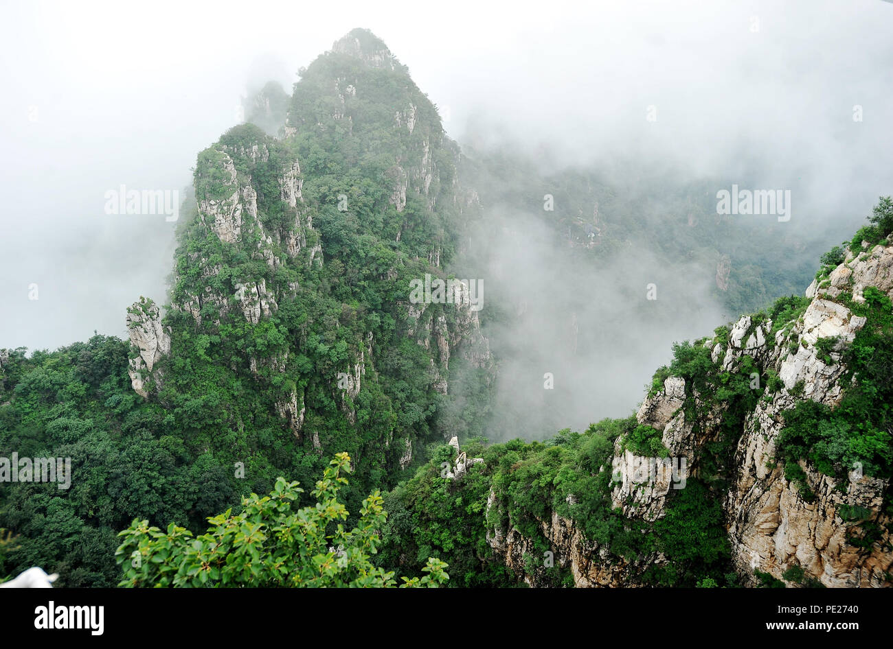 (180812) -- YIXIAN, Aug. 12, 2018 (Xinhua) -- Photo taken on Aug. 12, 2018 shows the view of Langya Mountain in Yixian County, north China's Hebei Province. Clouds and fog made Langya Mountain indistinct after a rainfall. Stock Photo