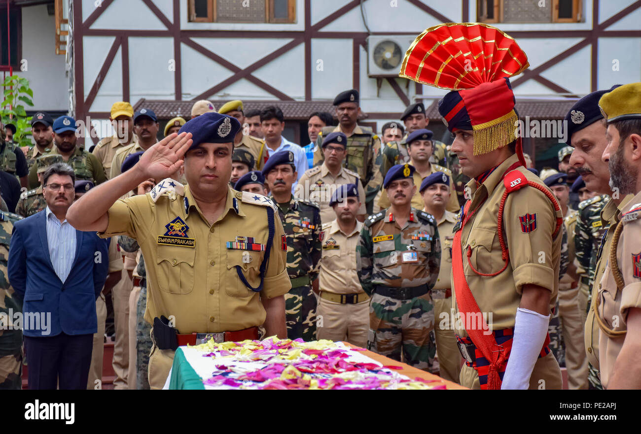 August 12, 2018 - Srinagar, Jammu & Kashmir, India - Indian police officer salute during the wreath-laying ceremony of their colleague Parvaiz Ahmad in Srinagar, Indian controlled Kashmir on Sunday. A gunfight between rebels and raiding government forces at a neighborhood in Indian-controlled Kashmir's main city on Sunday has killed a counterinsurgency police official and wounded at least three other security officials, police said.A gunfight between rebels and raiding government forces at a neighbourhood in Indian-controlled Kashmir's main city on Sunday has killed a counter insurgency polic Stock Photo