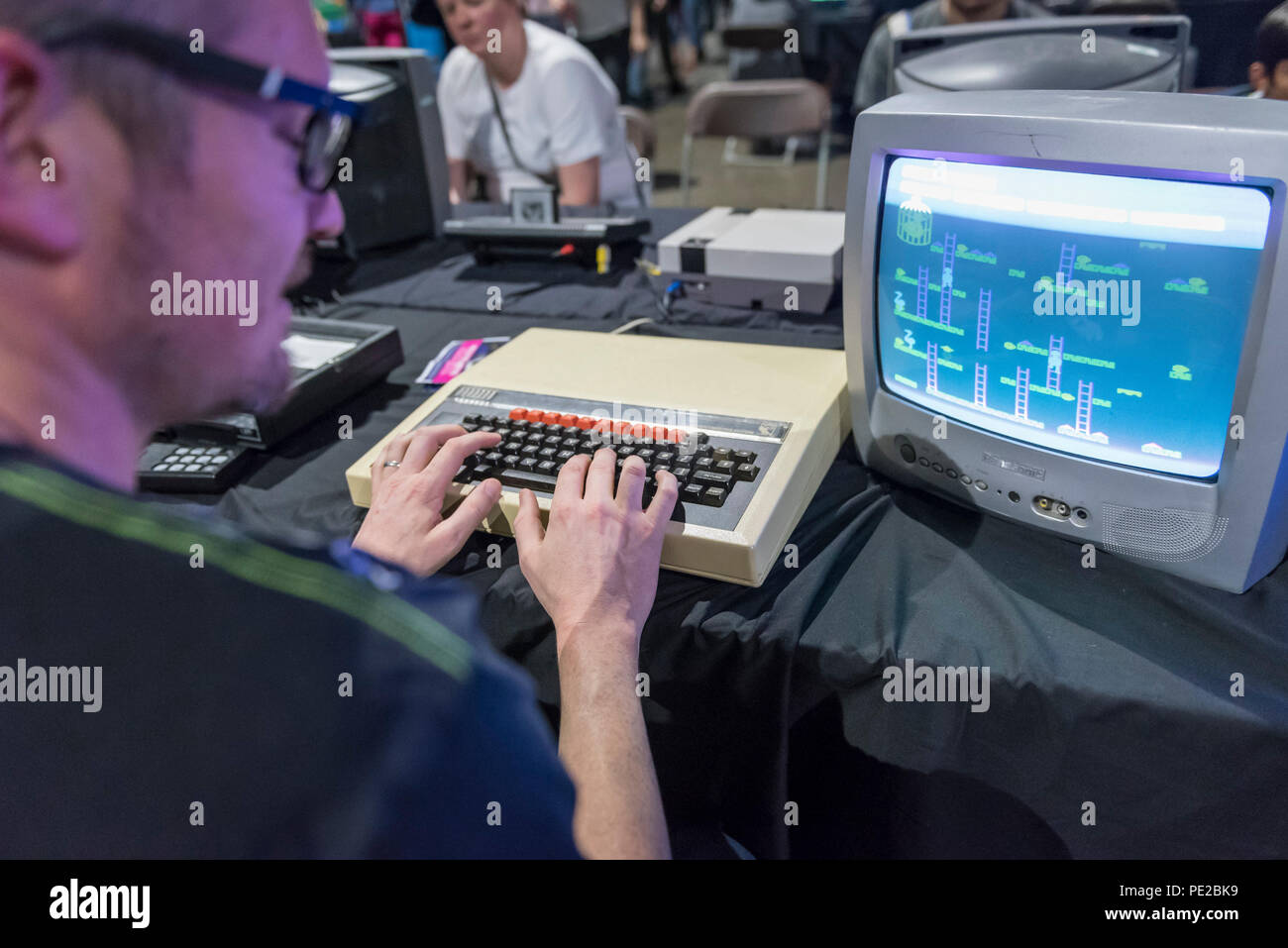 London, UK.  12 August 2018. A visitor plays on the iconic BBC Microcomputer at retro games festival PLAY Expo held in London for the first time at Printworks, Canada Water. Game enthusiasts visited to rediscover the classics, from Donkey Kong, Pong, Super Mario Bros. and Space Invaders to vintage pinball machines, VR, indie games and a dedicated Minecraft zone. The show also included a sneak preview of new retro gaming streaming service, Antstream.  Credit: Stephen Chung / Alamy Live News Stock Photo