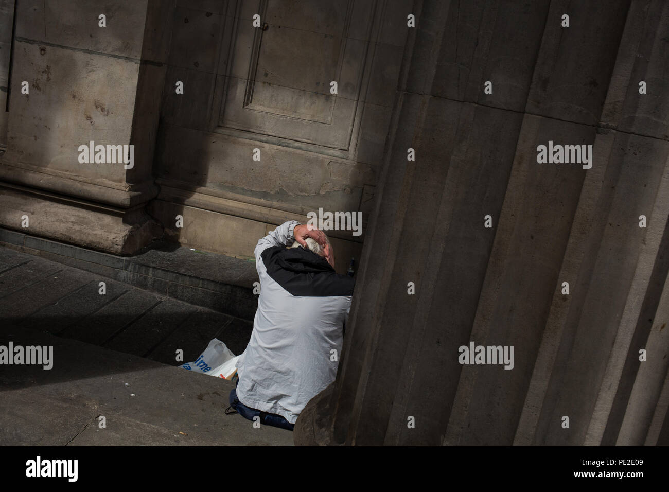 Man Sitting Combing Hair In Glasgow Scotland On 8 August