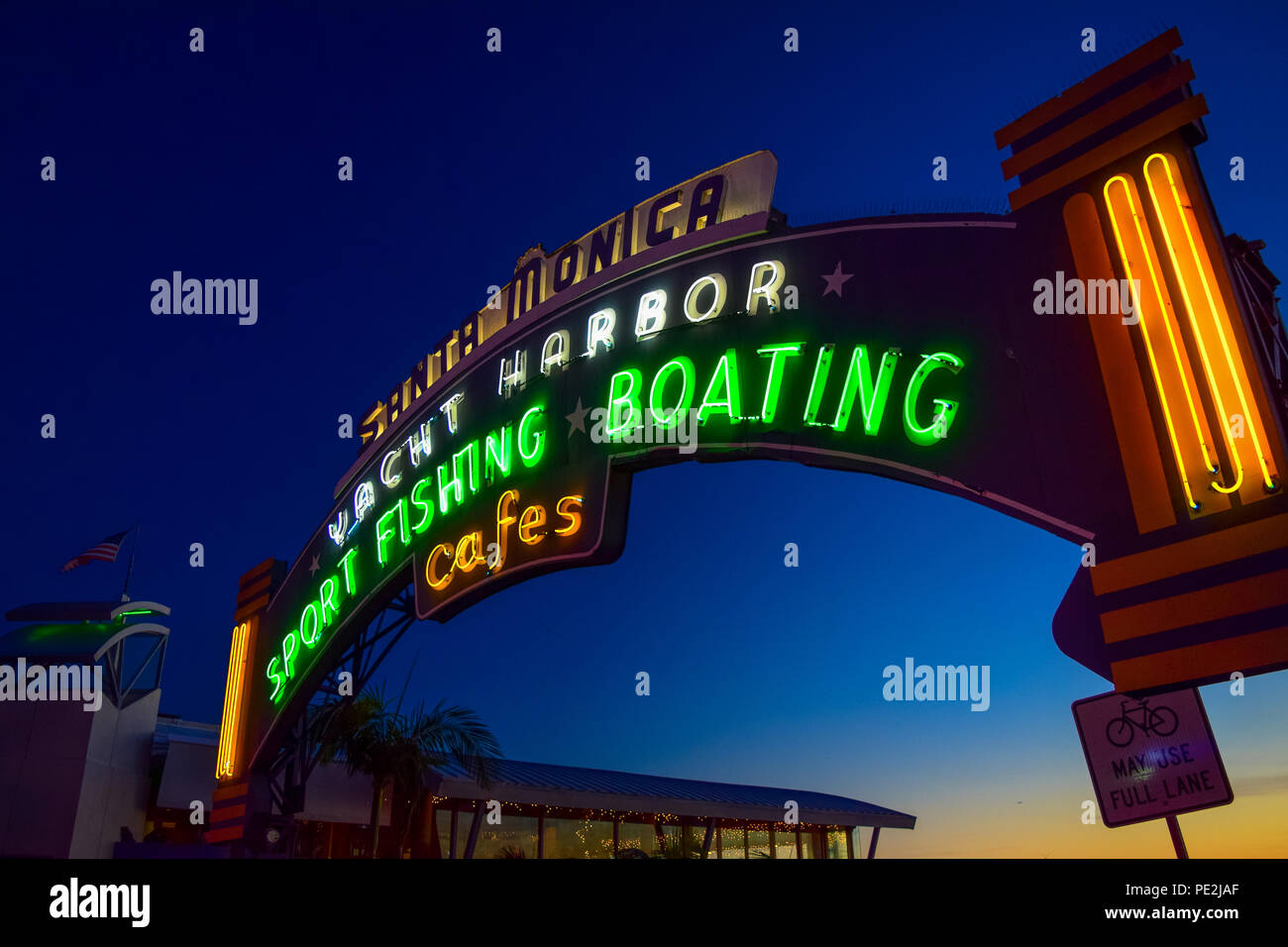 The Santa Monica Pier sign lit up at sunset in Santa Monica, California Stock Photo