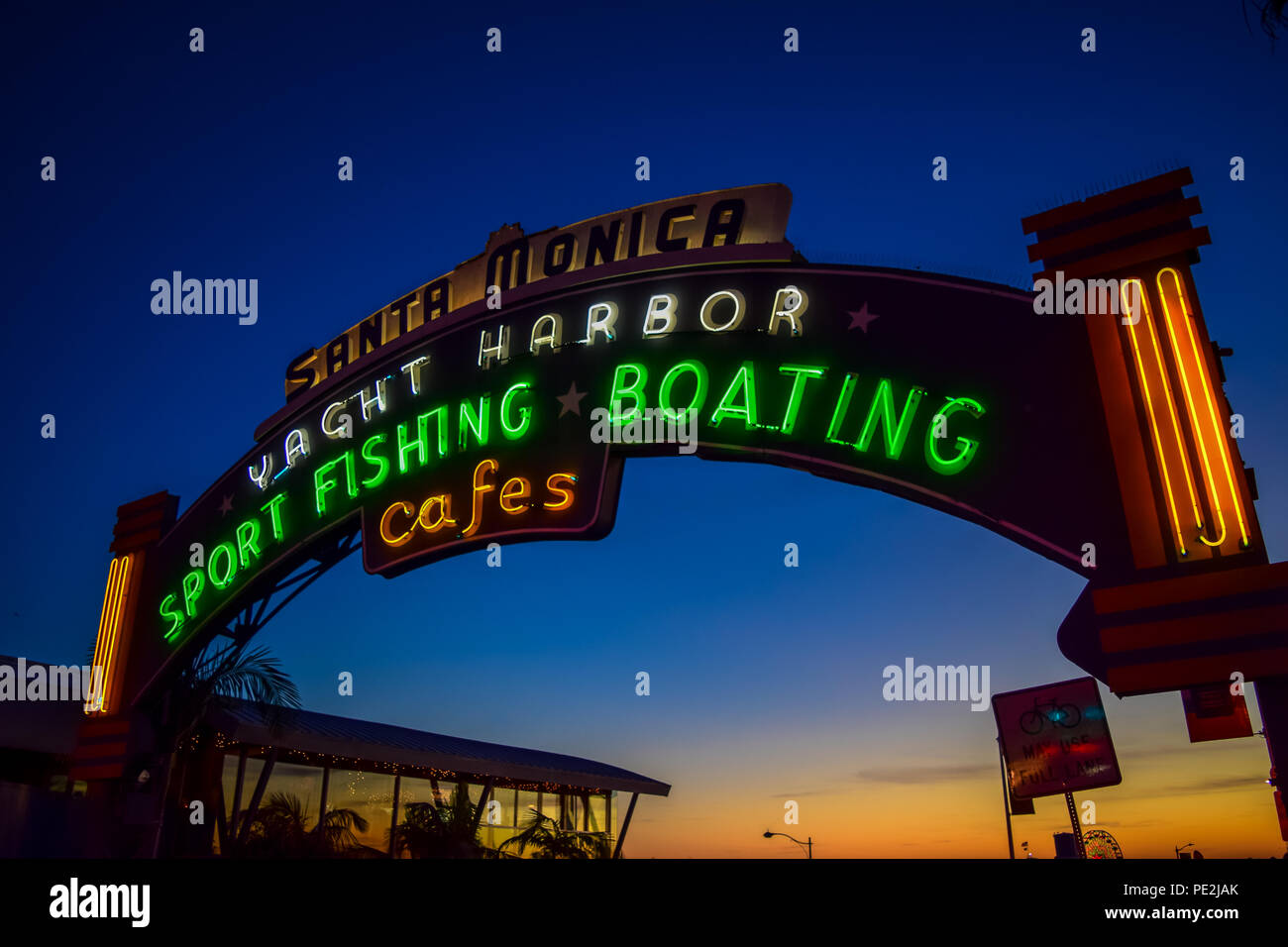 The Santa Monica Pier sign lit up at sunset in Santa Monica, California Stock Photo