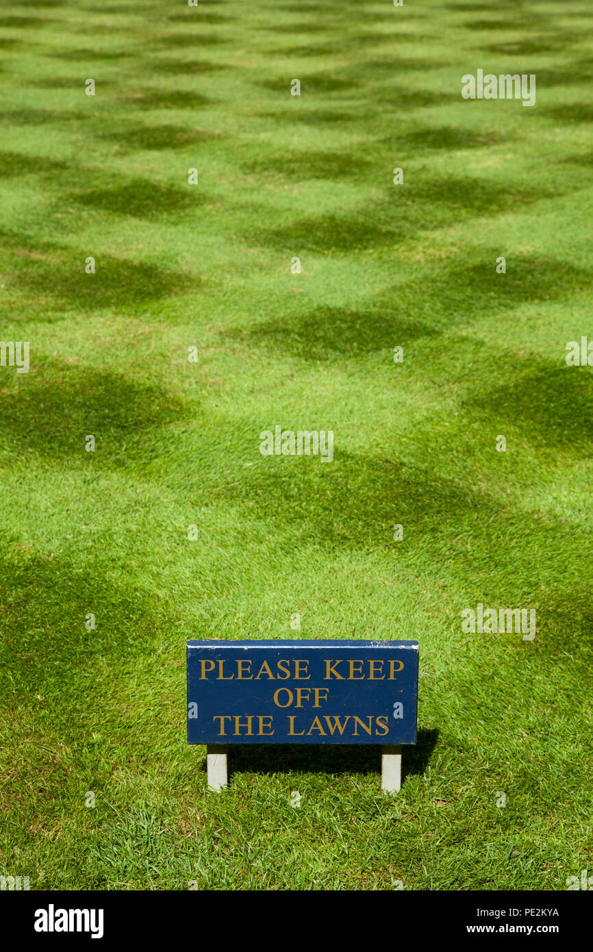 Striped freshly mown cut  lawn grass in the grounds of Trinity collage Oxford with a notice sign saying please keep of the lawns Stock Photo