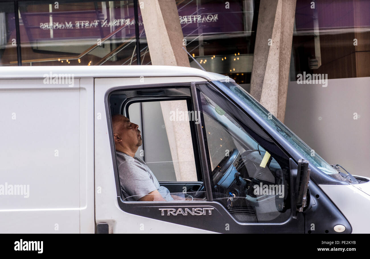 Man in driver's seat of van, sleeping, London, England, UK Stock Photo
