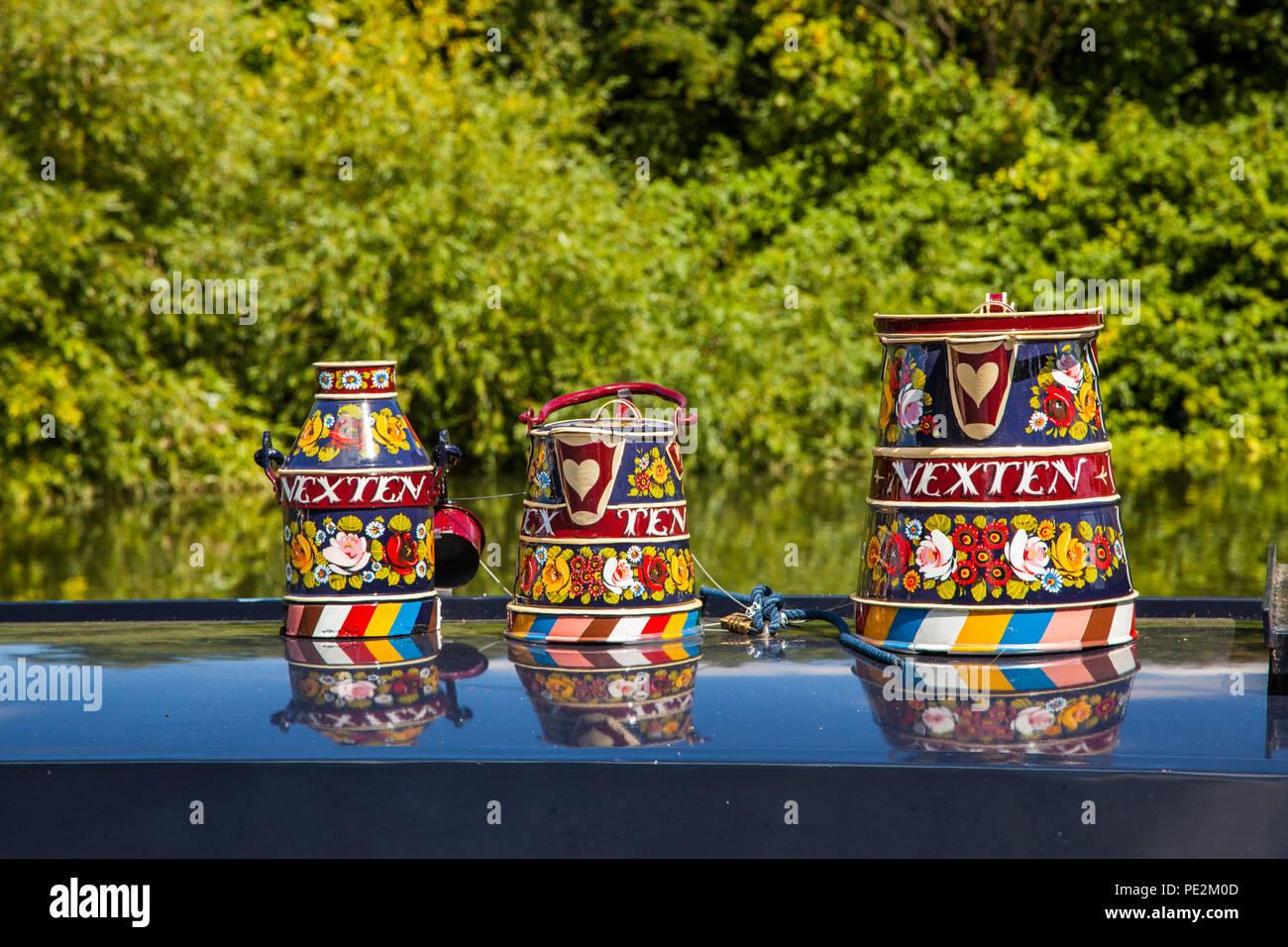 Brightly painted  buckets and jugs on the roof of a narrow boat on the English canal network Stock Photo