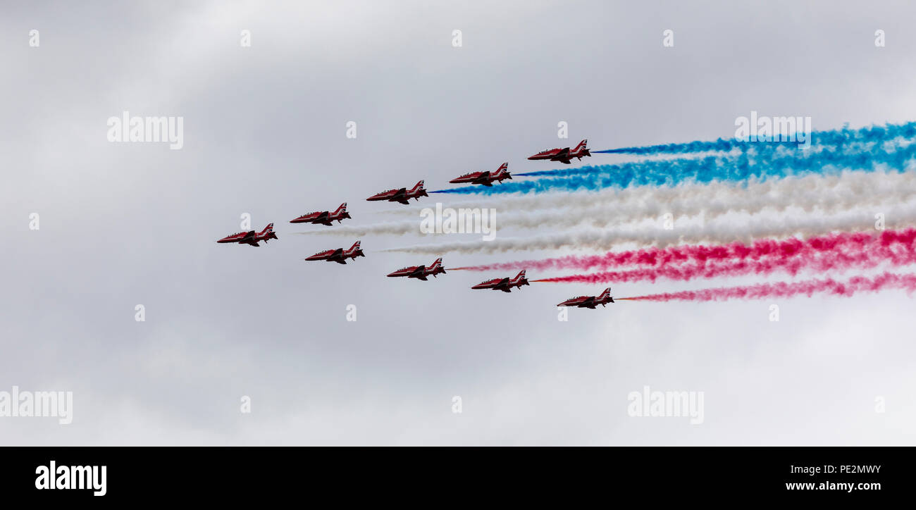 Red Arrows flypast with their iconic coloured smoke trailing behind Stock Photo