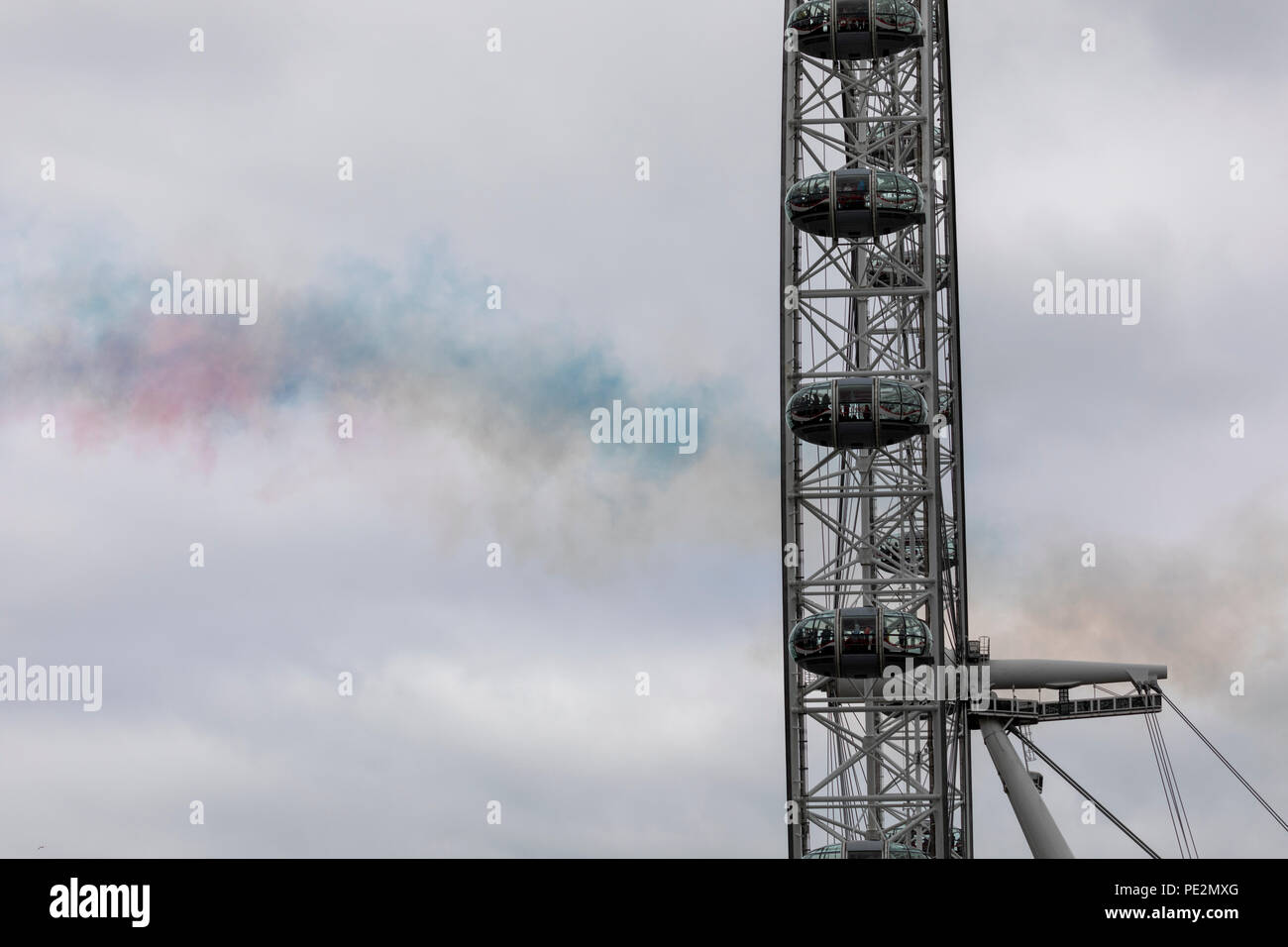Coloured smoke lingering in the air after a Red Arrows flypast over the London Eye Stock Photo