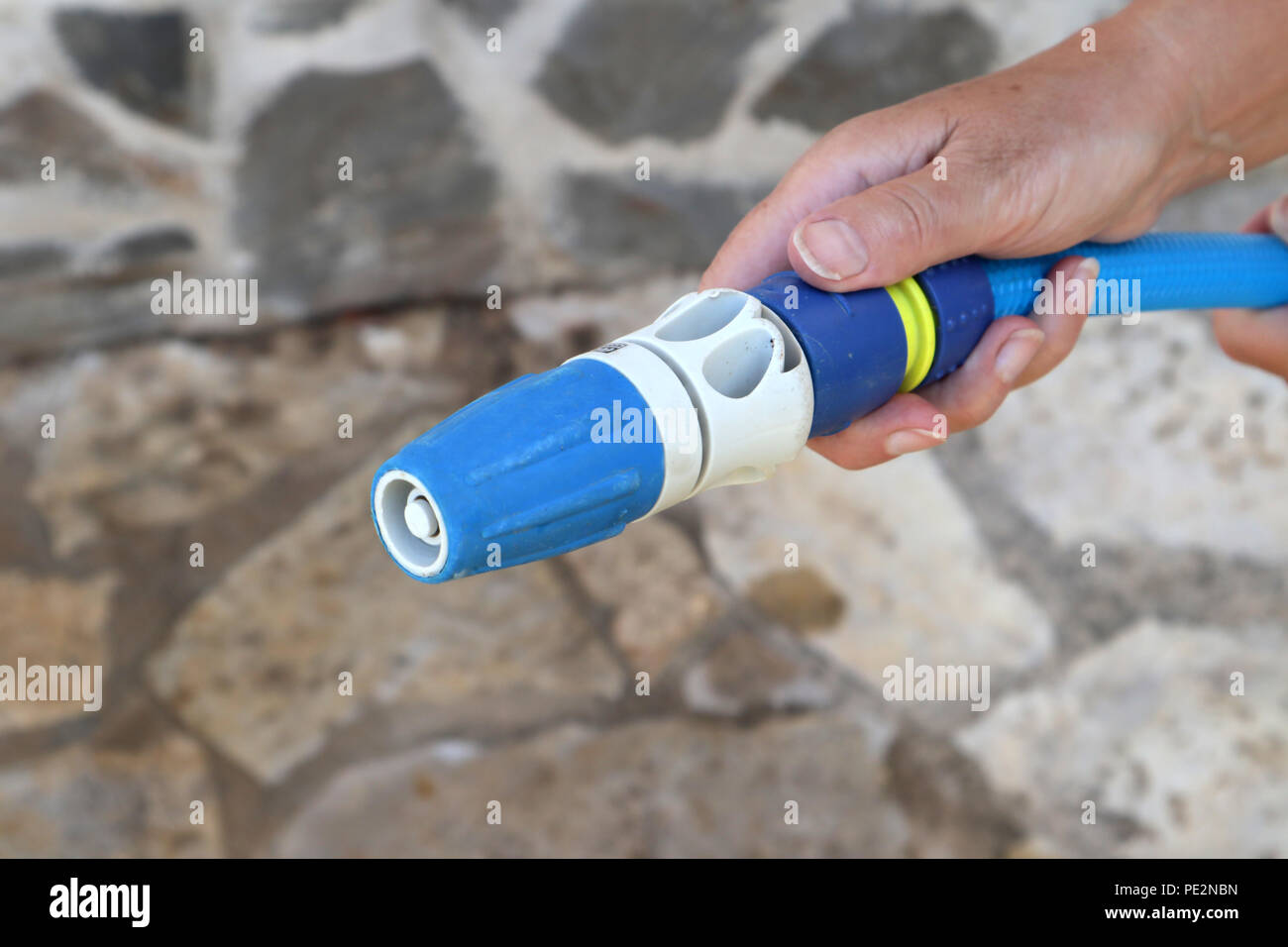 Using a hose pipe in the garden Stock Photo Alamy