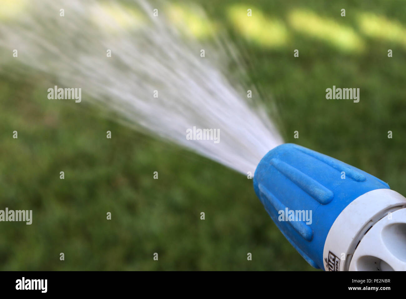 Using a hose pipe in the garden Stock Photo Alamy