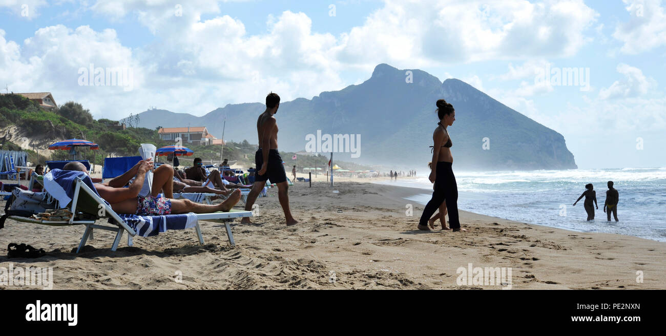 Relaxed people on the Sabaudia beach for the summer holidays. The Circeo Mountain on the background. Sabaudia, Lazio, Italy. Stock Photo