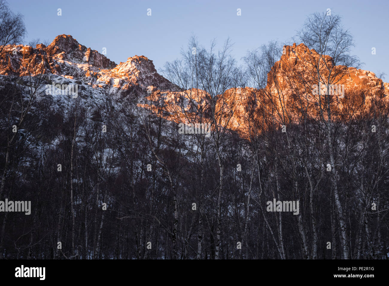 Sunrise sun strikes the mountain, behind the birch trees of Covao de Amentade, Serra da Estrella, Beira Alta, Portugal Stock Photo