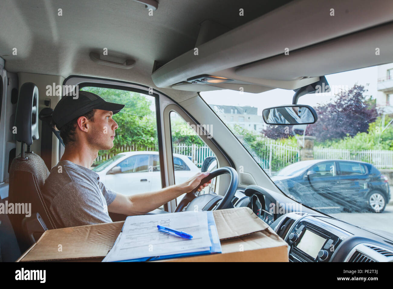 delivery transportation service job, driver man with package box driving truck car vehicle Stock Photo