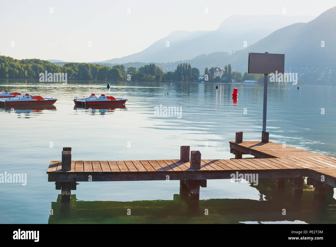 lake Annecy and beautiful mountain landscape, wooden pier La Tournette at sunrise early morning, France Stock Photo