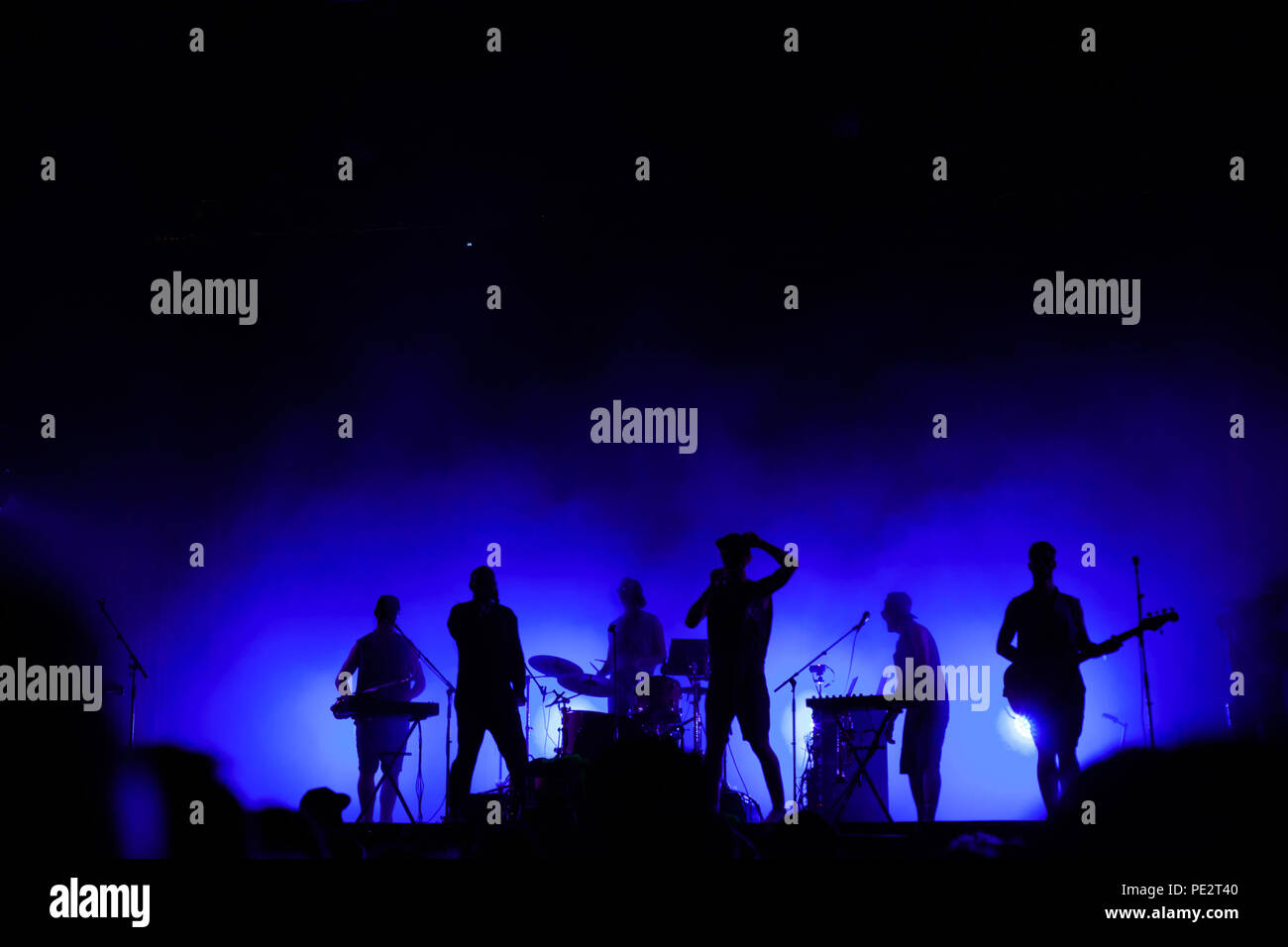 music band playing on concert stage, silhouettes of musicians unrecognizable, group of people singing together in rock festival Stock Photo
