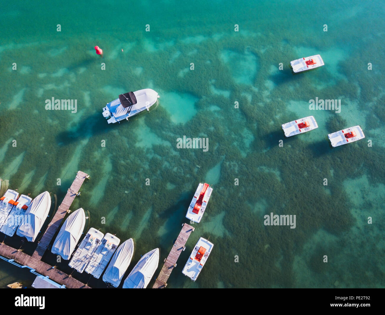 Annecy lake aerial landscape, top view of boats in blue turquoise water from drone, summer leisure activities Stock Photo