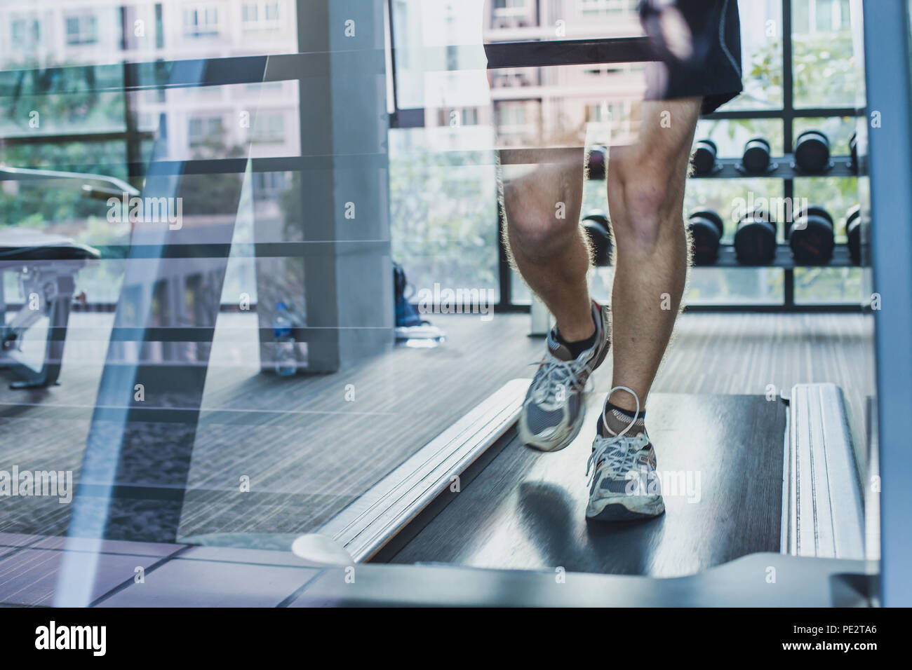 feet of runner on treadmill, sport exercises in fitness center, workout training, man on running track Stock Photo