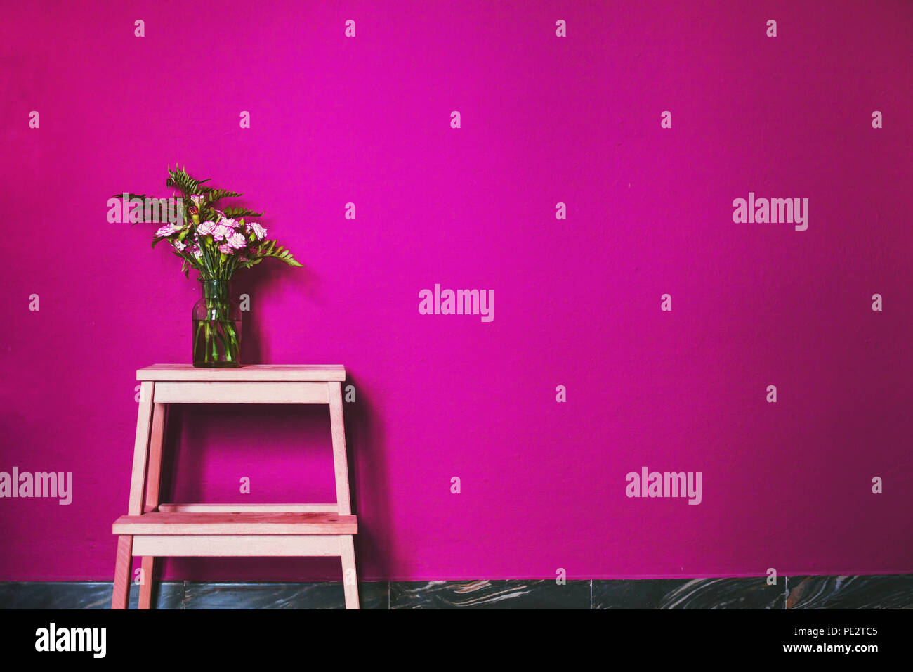 pink color in interior design decoration, painted wall and vase with flowers Stock Photo