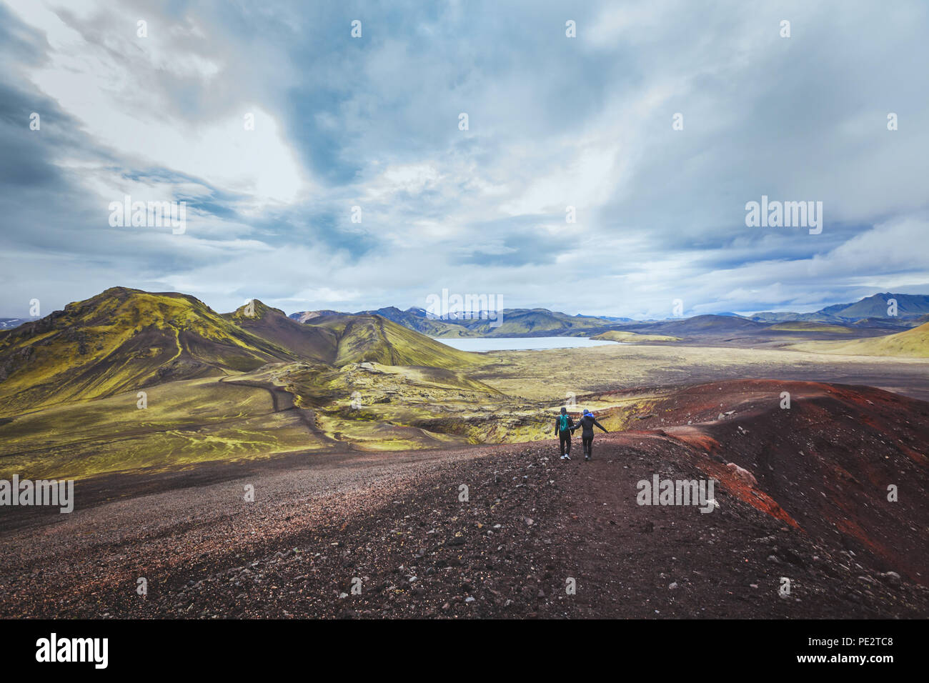 hiking in Iceland near Landmannalaugar, couple of backpackers walking in beautiful moon landscape, travel Stock Photo