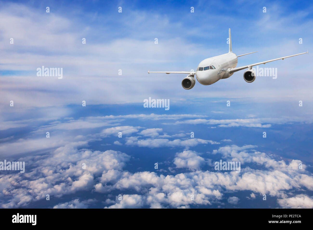 airplane flying above the clouds, travel concept, aircraft jet plane in blue sky Stock Photo