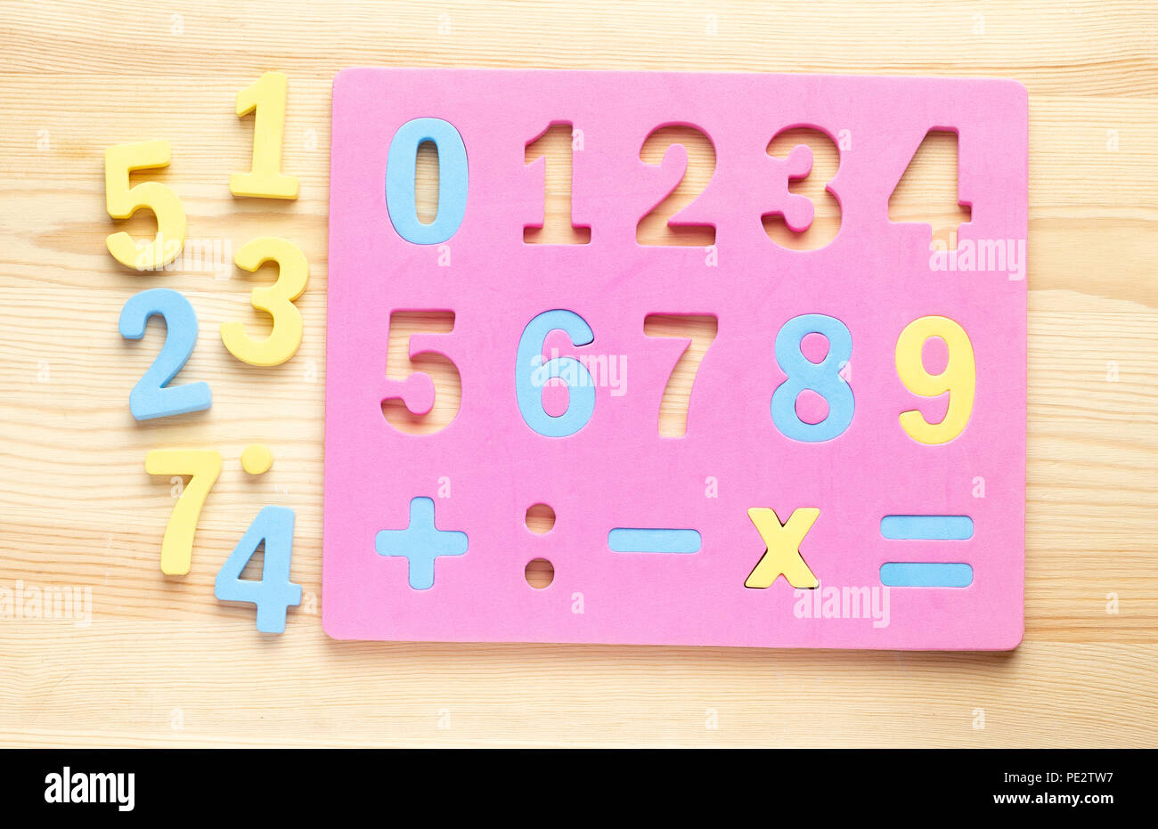 The child is studying the numbers and the account. Arranges the colored blocks to the desired numbers. Mathematics for children Stock Photo