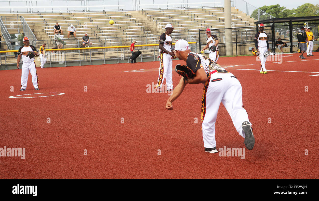 Members of the U.S. Marine Corps men's softball team warm up before a