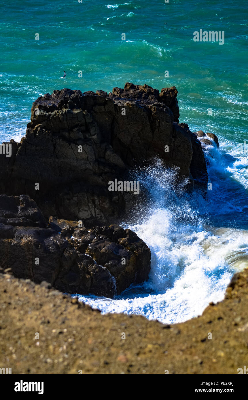Pacific Ocean waves crashing onto shore at Mugu Rock in Malibu, California Stock Photo
