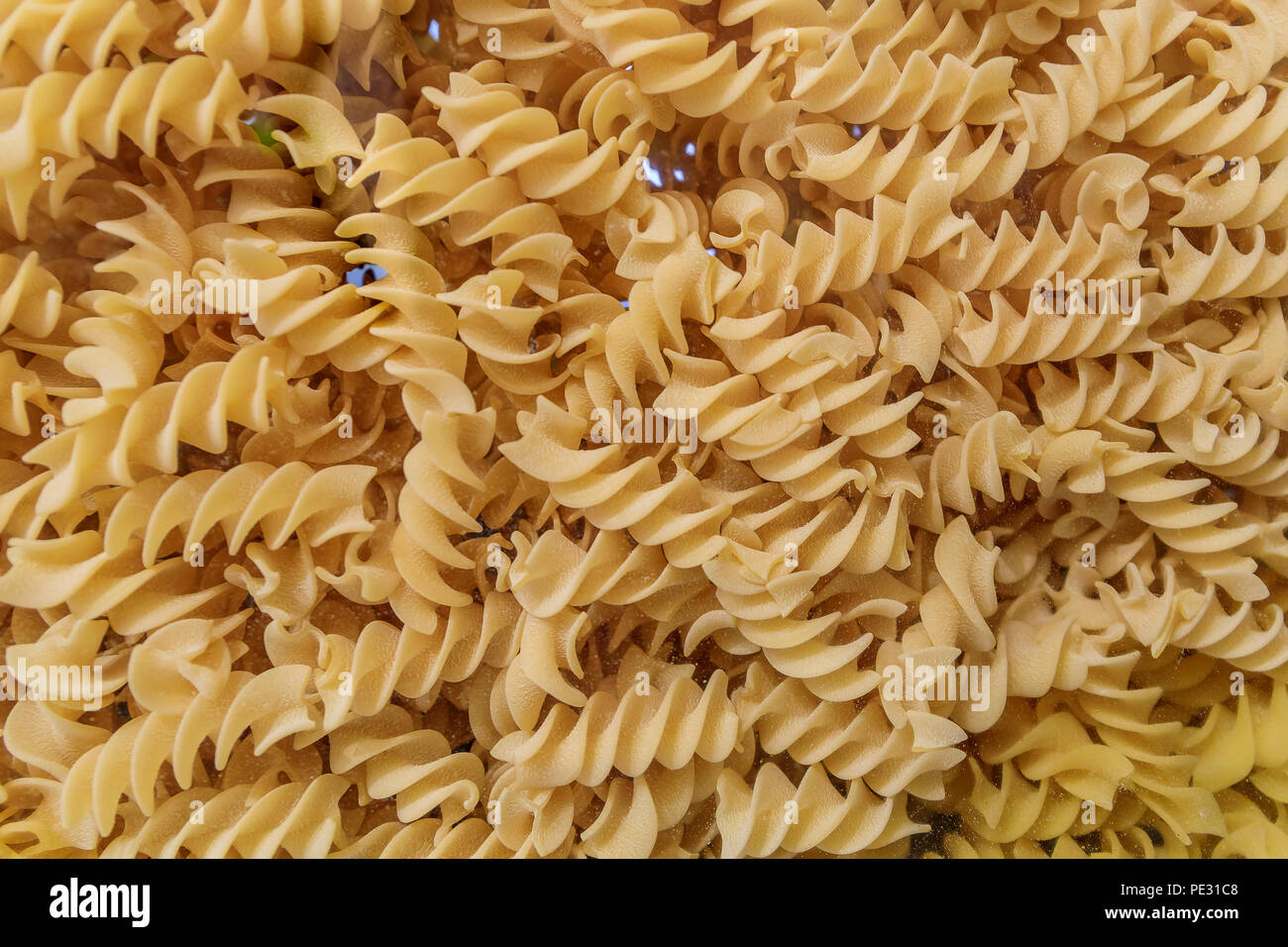Close up of fusilli or rotini pasta displayed in the background in an