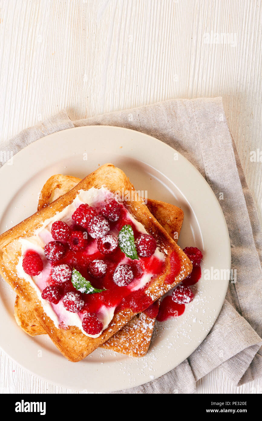 Healthy breakfast with toast and raspberries on wooden table Stock Photo