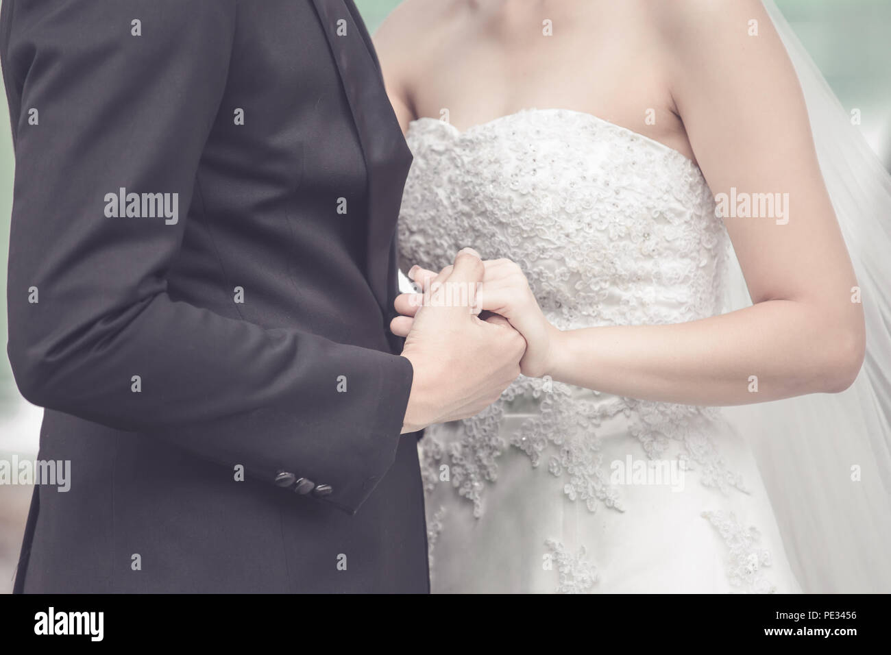 Married bride and groom holding hands as a symbol of love and happiness. Stock Photo