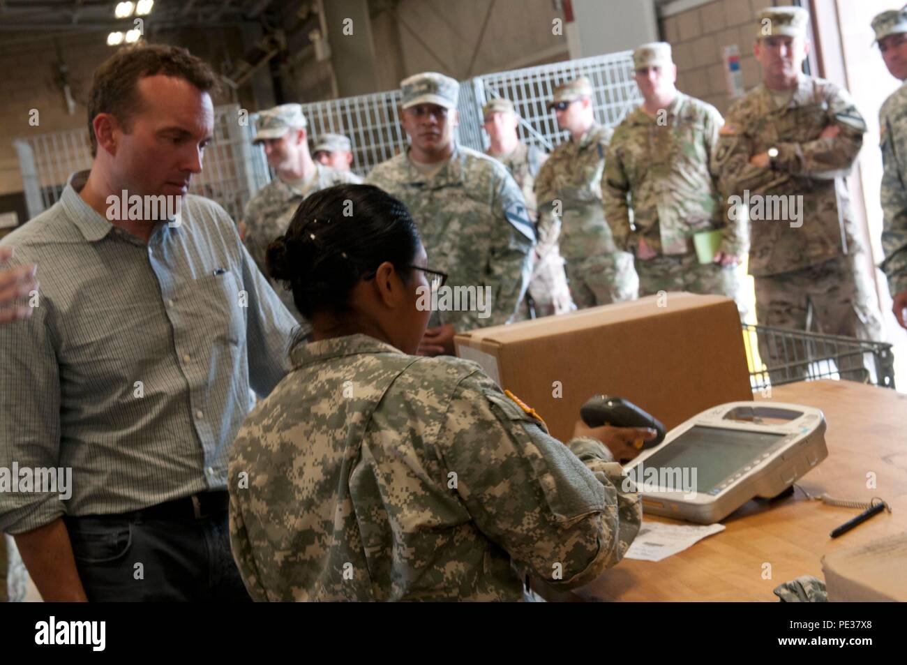 Spc. Rosa Santos, a Tucson, Ariz., native and unit supply specialist with the 215th Brigade Support Battalion, 3rd Armored Brigade Combat Team, 1st Cavalry Division, shows Acting Under Secretary of the Army Eric Fanning how the unit processes incoming parts Tuesday at Fort Hood, Texas. Fanning visited the 215th BSB motor pool to learn how Soldiers get the parts and equipment that they need. Stock Photo