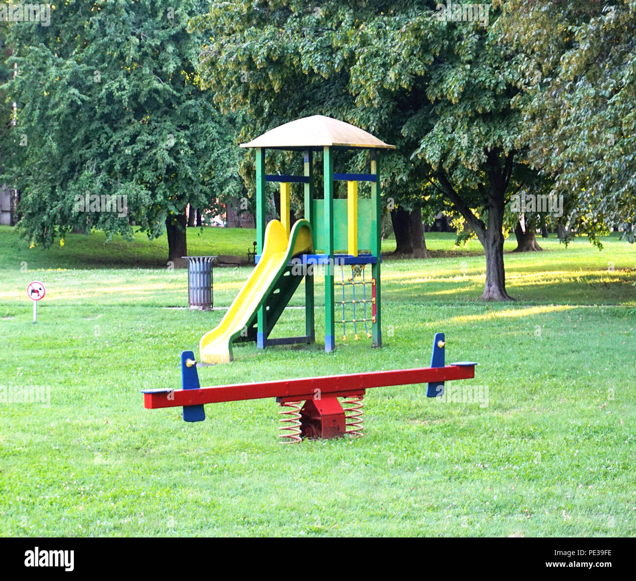 Green park in city with equipment for children playing, children