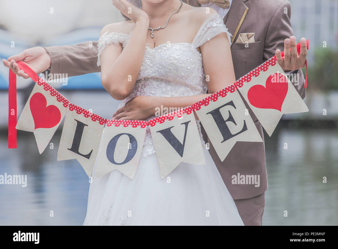 The bride and groom were happy to sign the meaning of love Stock Photo