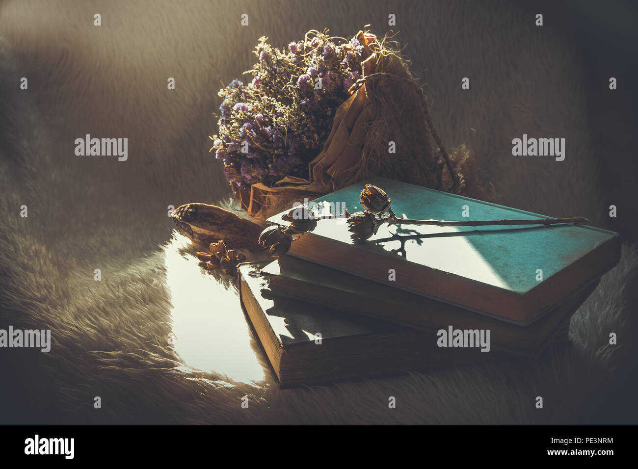 Still life with books and dried flowers offered in vintage colors and ...