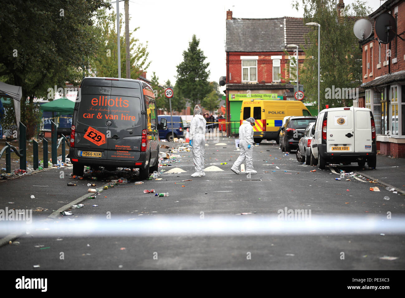 Forensics officers at the scene in Claremont Road, Moss Side, Manchester, where ten people, including two children were taken to hospital after reports of gunshots at a street party. Stock Photo
