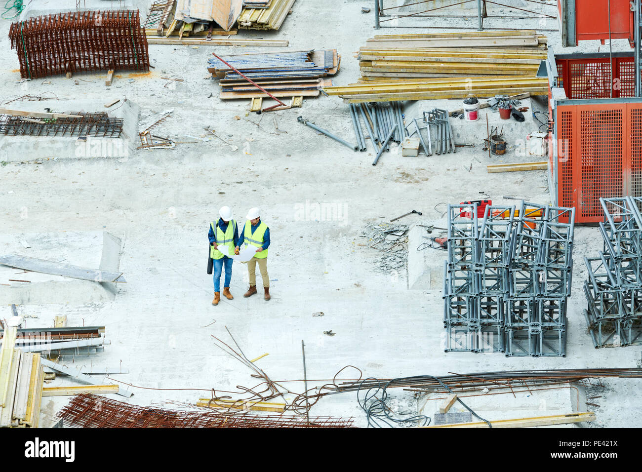 Building inspectors reading blueprint on construction site Stock Photo