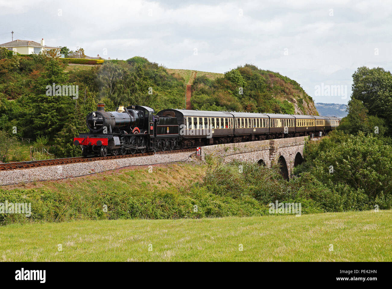7827 Lydham Manor heads past Broadsands on the Dartmouth steam railway. Stock Photo