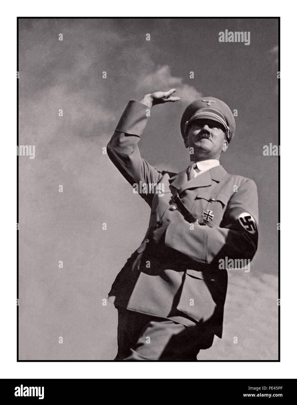 ADOLF HITLER SALUTE 1939 WW2 German propaganda  image of Adolf Hitler in military uniform wearing a Nazi swastika armband saluting ’Heil Hitler’ to a crowd low angle view with sky background Stock Photo